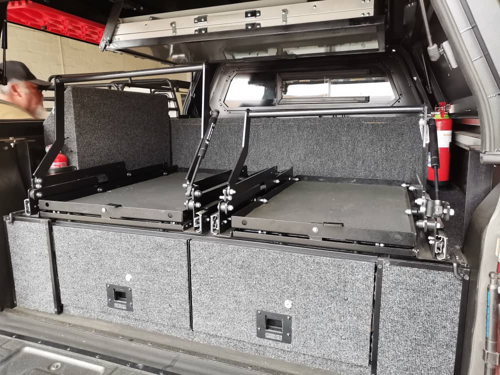 Customized drawer system for double cab with 2 drawers, 2 sliders, side loading compartments and battery system. Canopy bracket for the table.